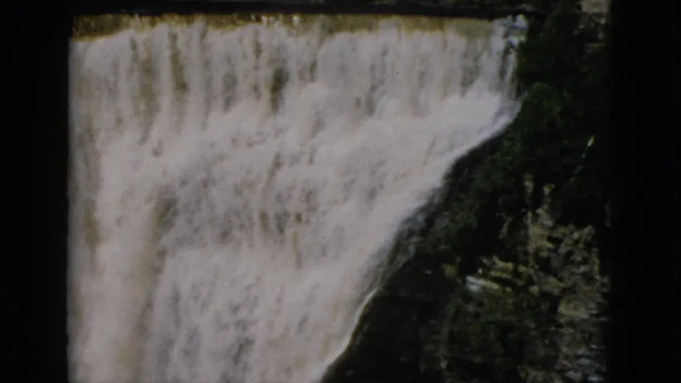 8mm footage c. 1952, Quebec, Canada: end of camera pan showing cascading falls and gorge interior with vegetation on rocky walls.