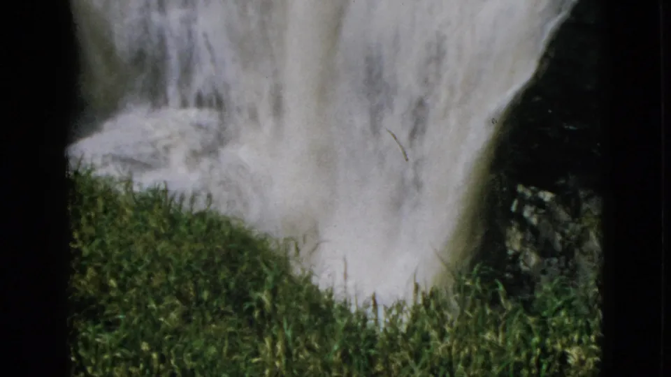 8mm home movie, circa 1952, Quebec Canada — waterfall beside prominent green mossy embankment with dark rock surface and bright daylight