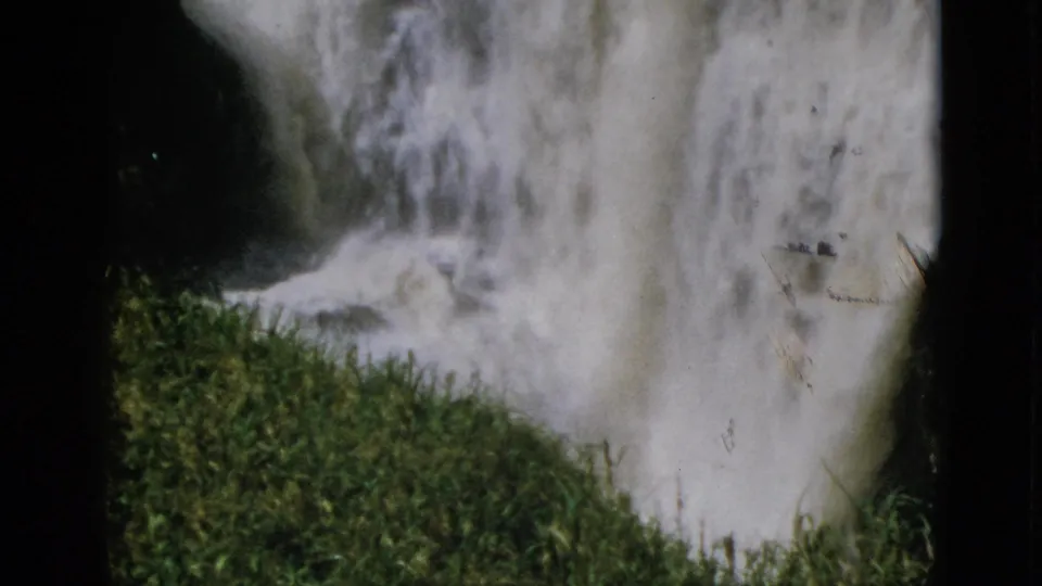 8mm home movie, circa 1952, Quebec Canada — churning white water at waterfall base with dark rocks and green grass in lower foreground