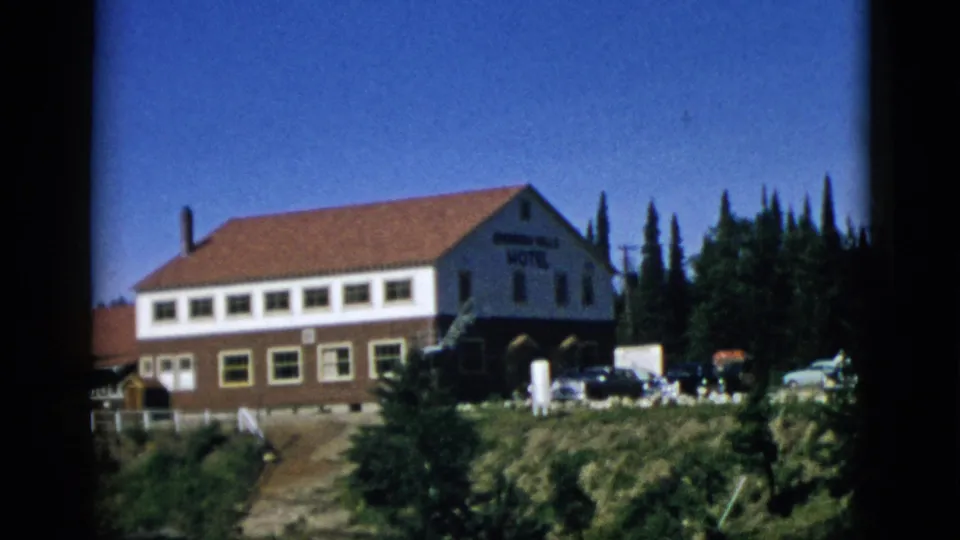 Closer view of the falls-side hotel with partially legible sign and 1950s cars in foreground; Quebec, Canada, circa 1952 8mm footage.