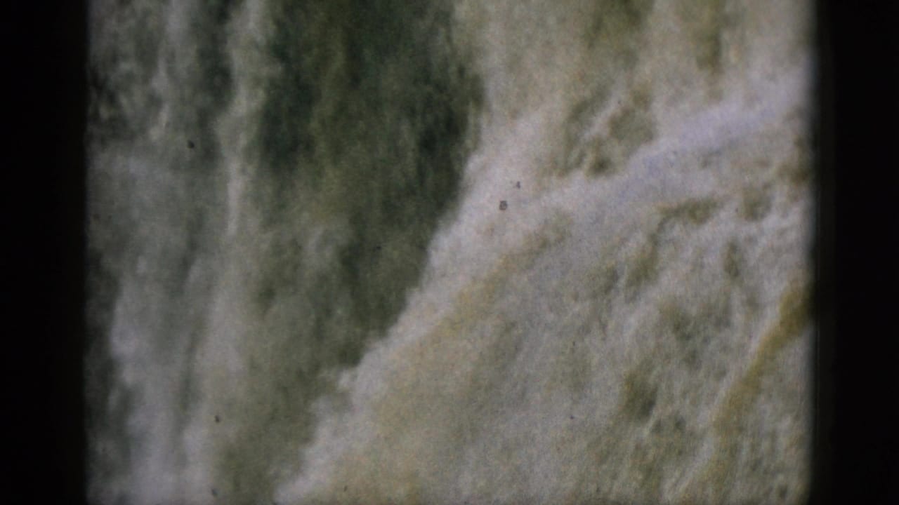 Rushing waterfall filling the frame in aged 8mm color footage