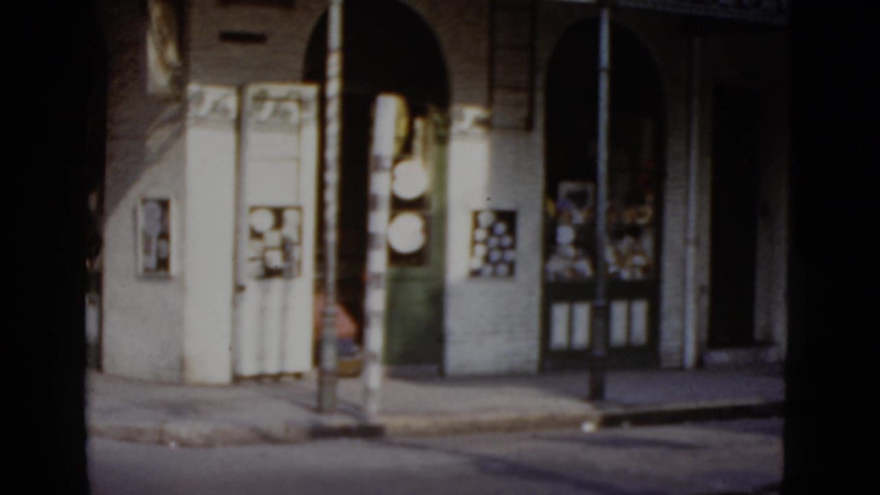 Street-level view of an arcade colonnade with arched openings and decorative pilasters; items visible in storefront displays beneath the arcade.