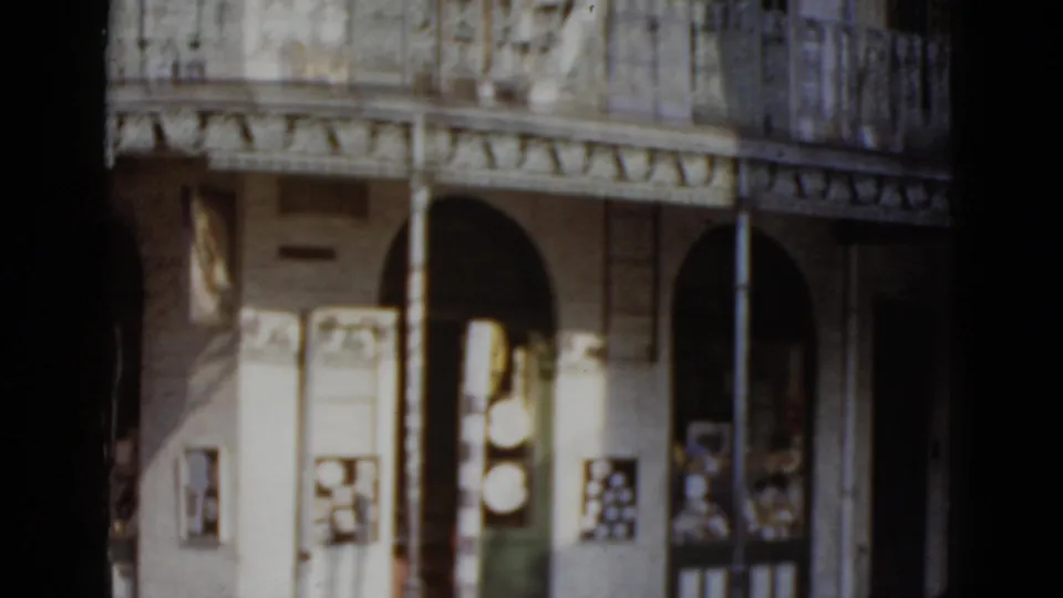 Elaborate cast-iron gallery railings and arched colonnade of a French Quarter-style building in New Orleans, circa 1952 8mm home-movie footage.