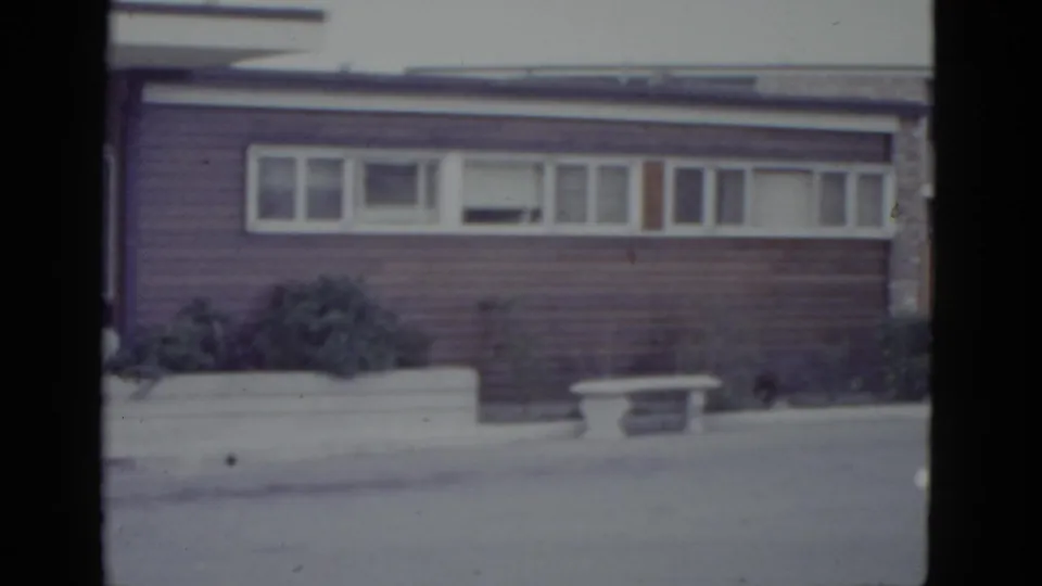 1950s ranch-style house with horizontal ribbon windows and concrete planter, filmed on 8mm circa 1952, possibly New Orleans area.