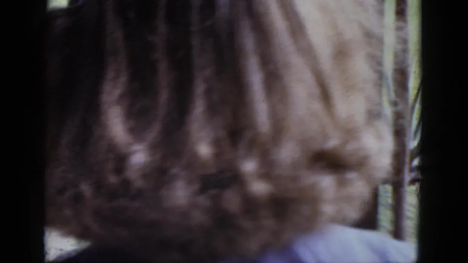 Out-of-focus close-up of a person's brown hair filling most of the frame; final moment of a 1952 8mm home movie.