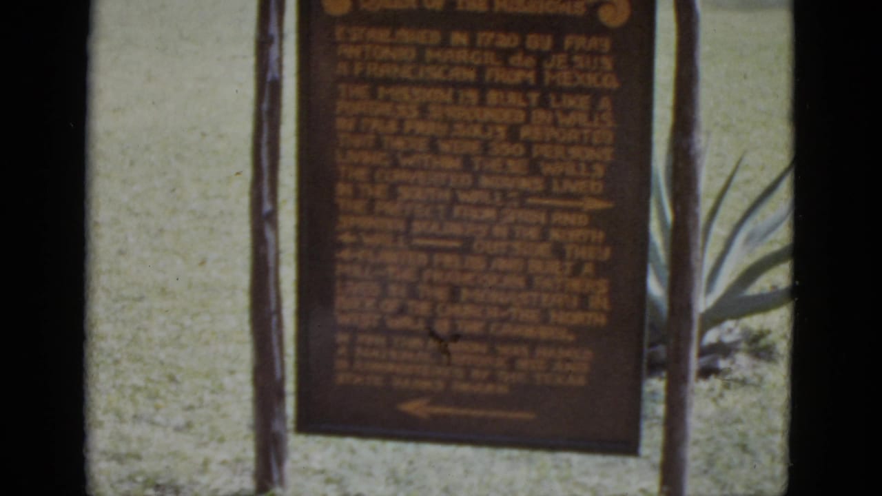 8mm close-up of the San José Mission 'Queen of the Missions' historical marker, likely San Antonio, Texas, circa 1952, with agave plants and lawn in background.