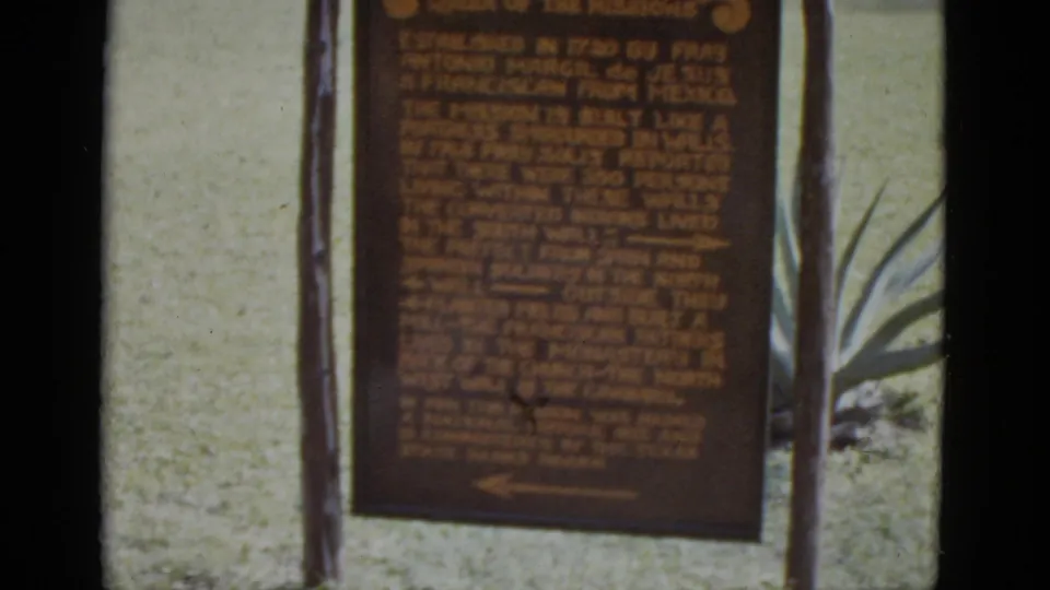8mm close-up of the San José Mission 'Queen of the Missions' historical marker, likely San Antonio, Texas, circa 1952, with agave plants and lawn in background.