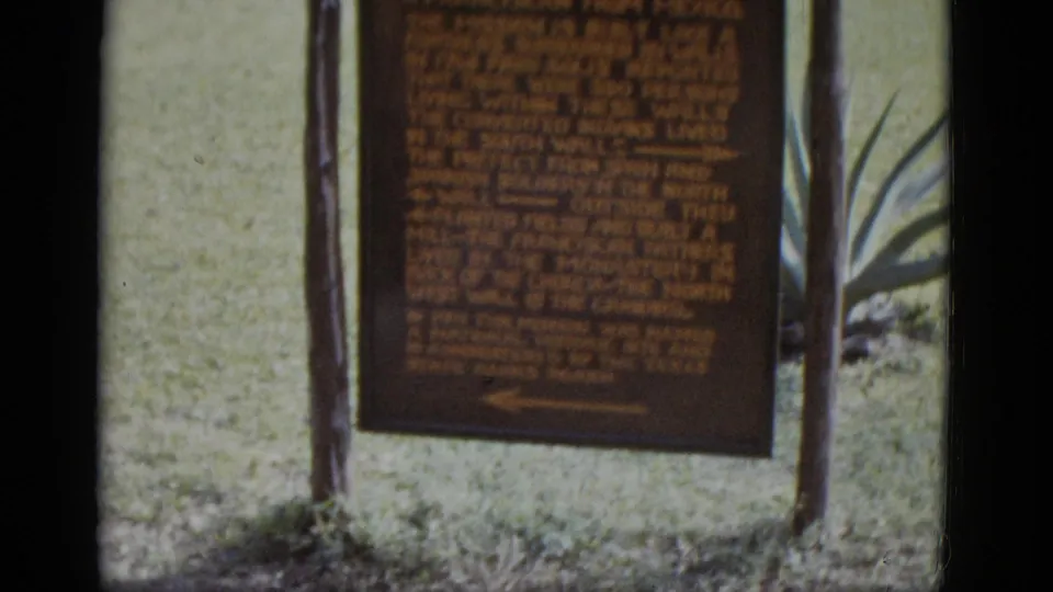 8mm frame of the San José Mission historical marker with founding text referencing 1720, flanked by agave plants and lawn, circa 1952.