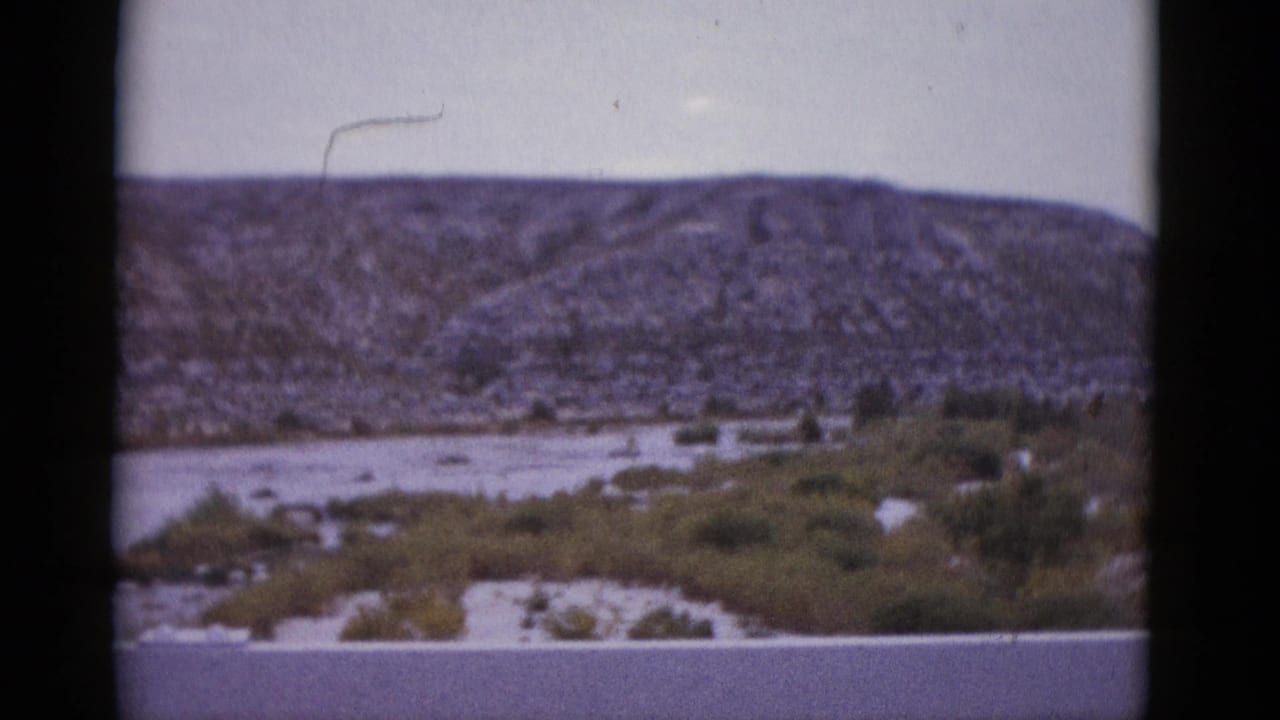 Texas arid mountain range and dry wash, 8mm home movie c. 1952; hair artifact visible on emulsion upper right.
