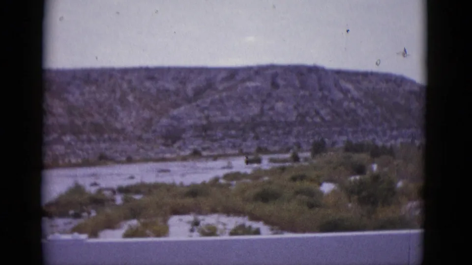 Texas mountain range looming over arid wash and scrubland, 8mm home movie c. 1952.