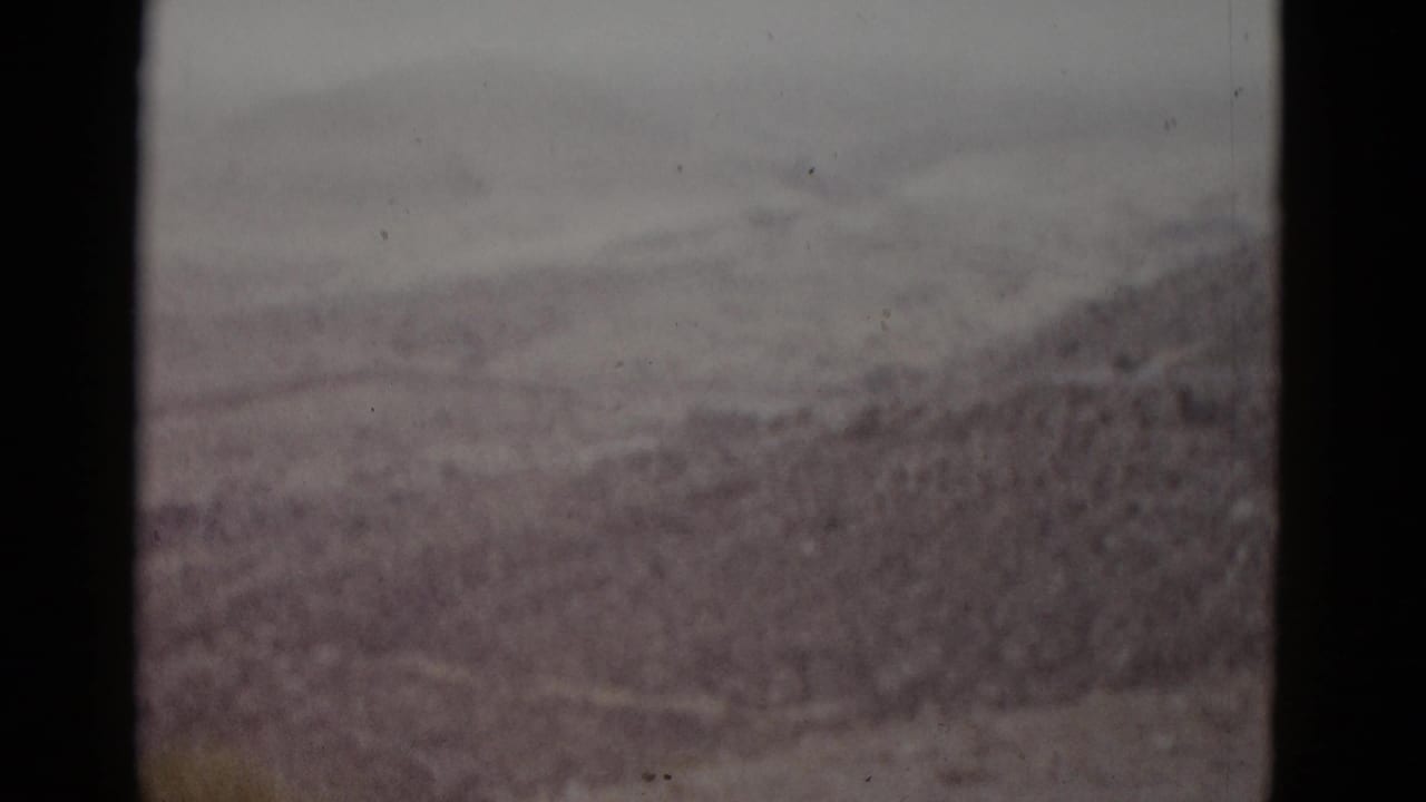 8mm home-movie frame, likely Utah, 1952 — rolling earth mounds and dry scrubland under an overcast sky.