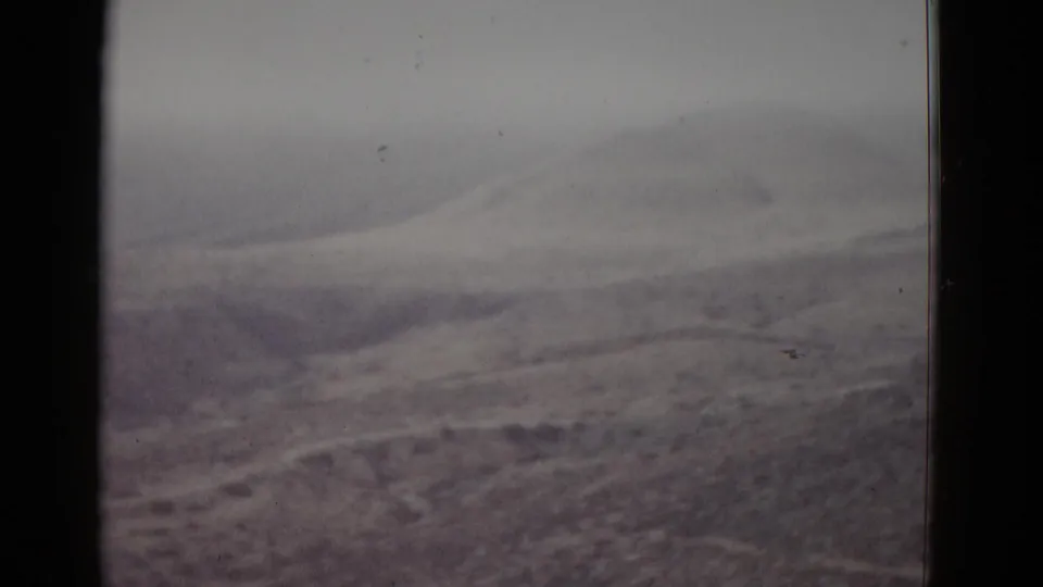 8mm home-movie frame, likely Utah, 1952 — layered dirt mounds and bare terrain receding into a hazy sky.