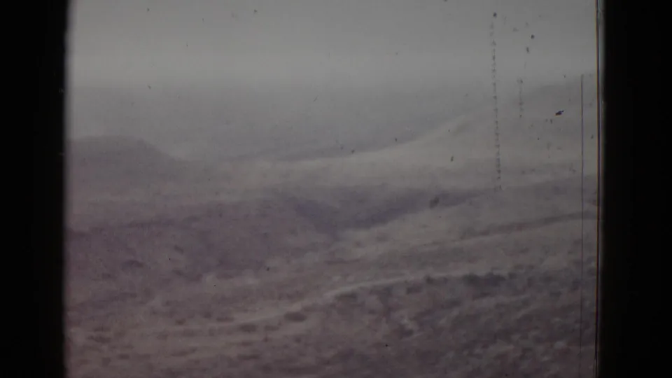 8mm home-movie frame, likely Utah, 1952 — open arid basin with low rolling mounds and visible vertical film scratches.