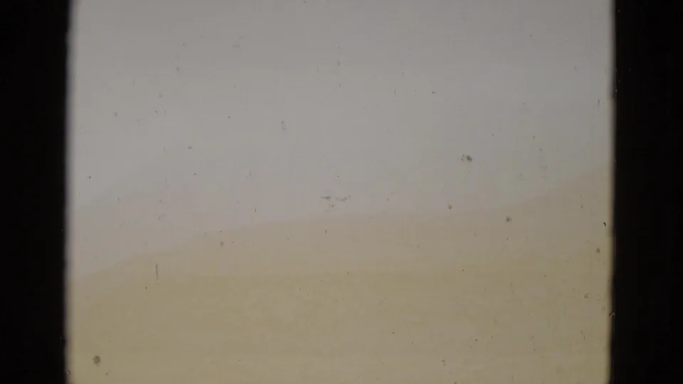 Heavily overexposed 8mm frame from the same Utah landscape sequence, showing significant film degradation; a faint warm yellow band at the lower edge is the only remaining detail.