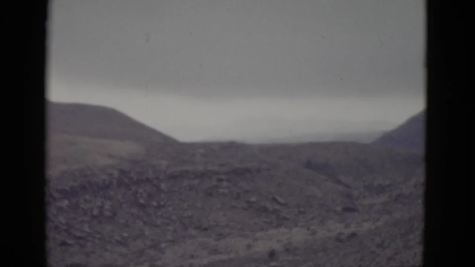 Arid Utah desert landscape with rolling brown hills and overcast sky, filmed on 8mm during a cross-country road trip circa 1952.
