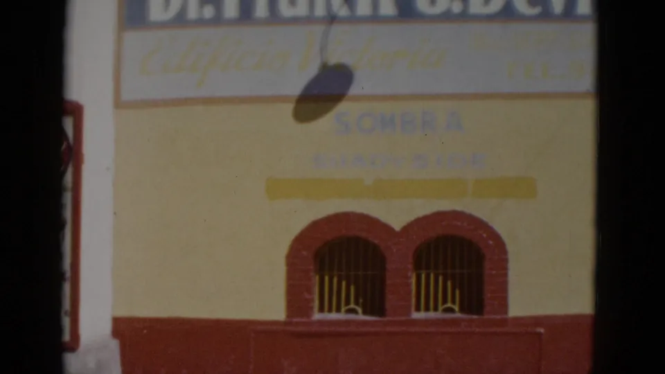 Red and yellow venue building facade with 'Edificio Victoria' and 'SOMBRA' signage; Plaza Ciudad Juarez sign at left edge; northern Mexico, circa 1952.