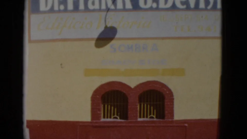 Yellow-and-red commercial building facade in Baja California, Mexico, circa 1952, showing 'Dr. Frank J. Devlyn,' 'Edificio Victoria,' and 'SOMBRA' painted signage.
