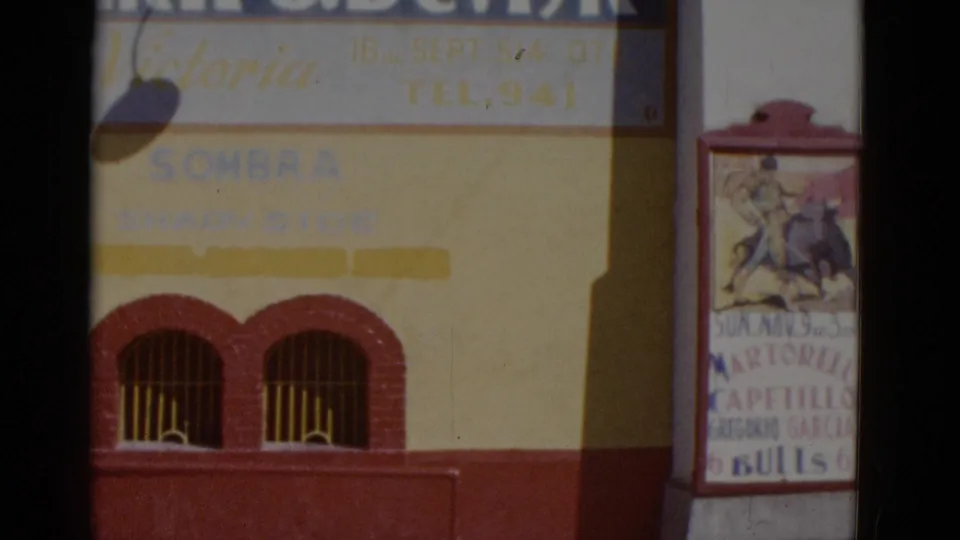 Baja California street scene, circa 1952: Edificio Victoria building facade at left and a bullfight event poster on a red-framed pillar board listing matadors including Capetillo.