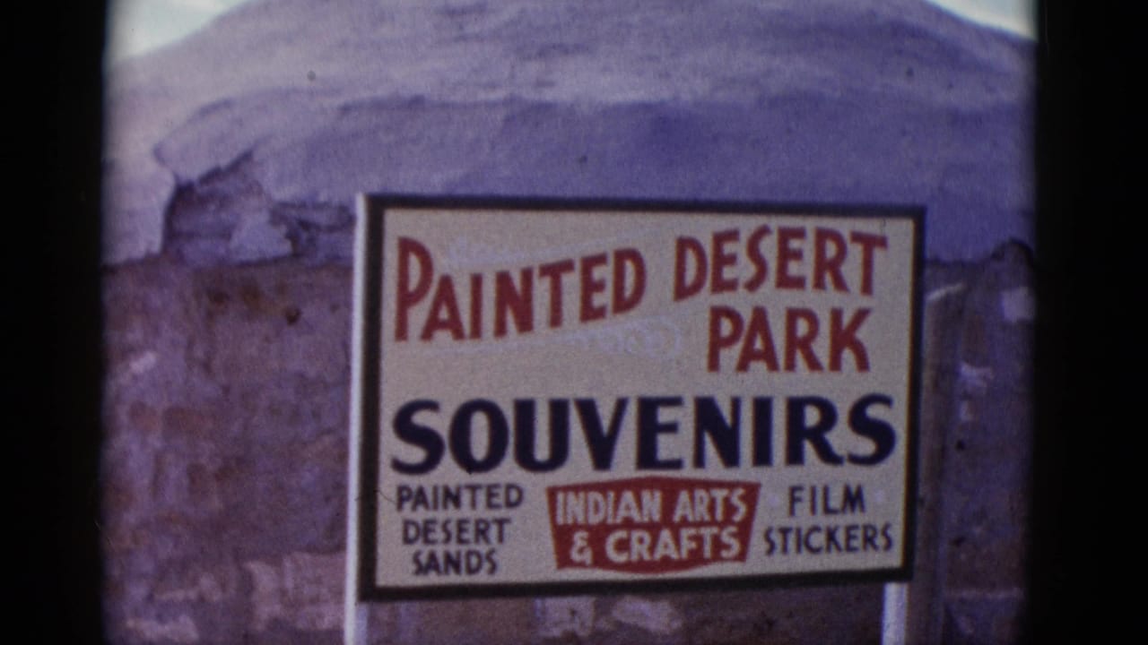 Painted Desert Park souvenir sign with desert formations behind it.