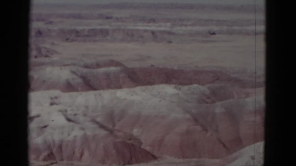 1952 8mm frame showing an arid Arizona desert landscape with pale eroded ridges and visible film borders.