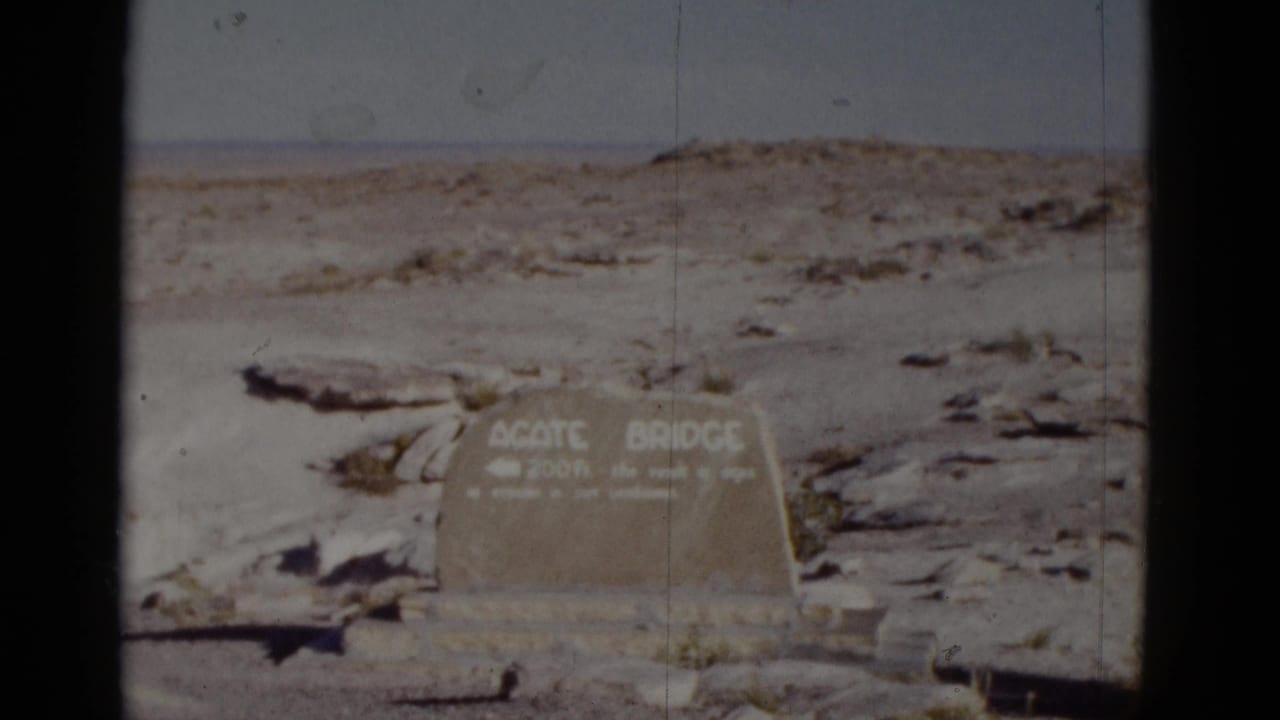 Agate Bridge sign in rocky desert with faded sky and film edge.