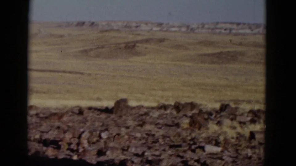 Arizona 1952 home-movie view of an arid open plain, rocky foreground, low distant ridges, and soft faded 8mm color.