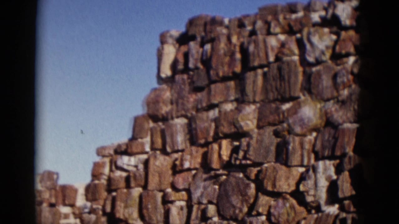 Stone wall corner with blue sky and dark film border at the side.