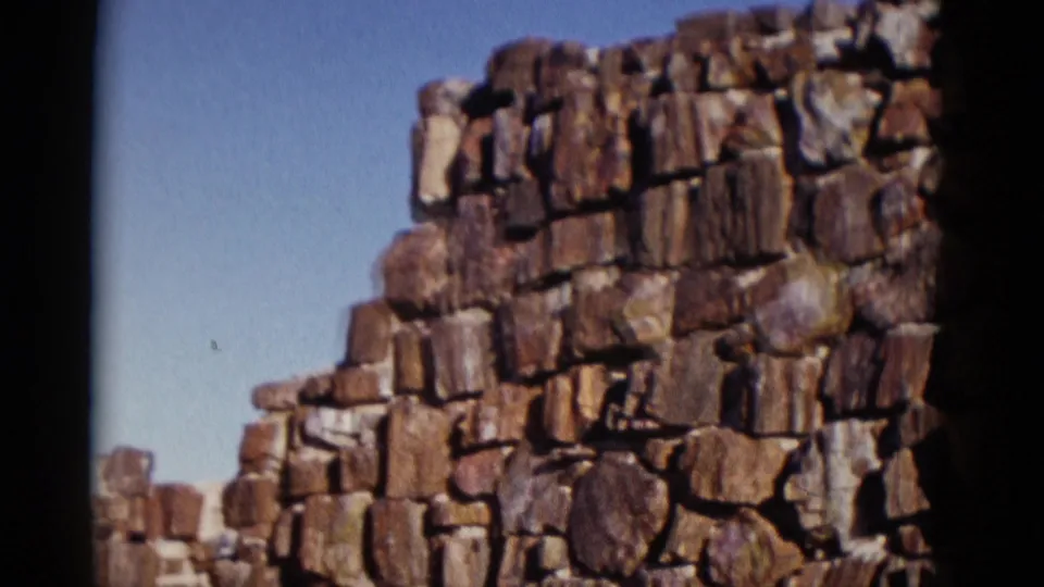 Arizona 1952 frame showing a stepped section of rugged stonework with sky behind it and dark film-edge shadow.