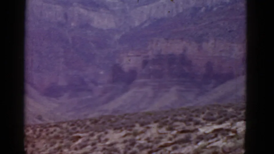 Final frame of the 1952 Arizona desert view, showing canyon walls and scrubland with visible 8mm grain and color shift.