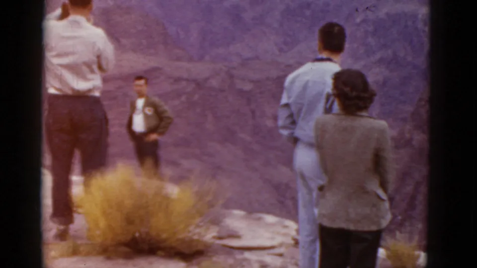 Adults at an Arizona canyon overlook in 1952, with a man in a light shirt near a shrub and others looking outward.