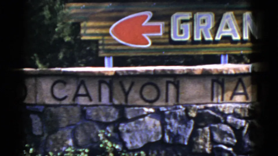 1952 Arizona frame with a red left-pointing arrow above partial Grand Canyon National Park lettering and a stone base.