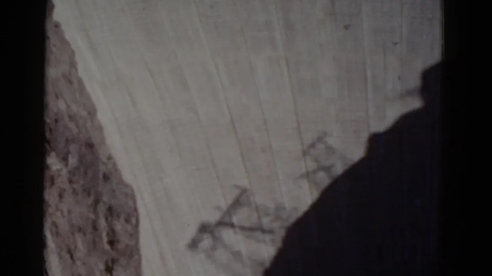1952 8mm view looking down at Hoover Dam's concrete face and adjacent canyon rock from a high vantage point.
