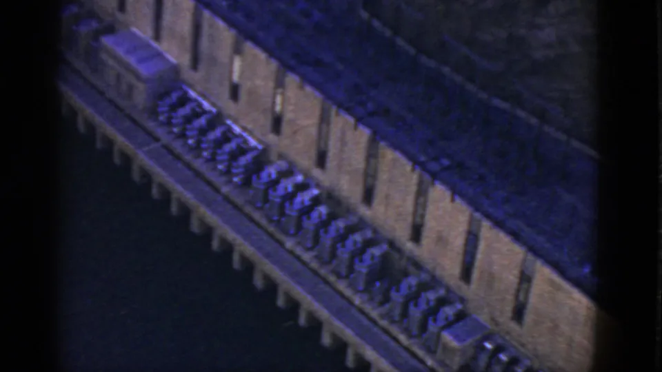 1952 California home-movie frame showing the channel structure receding diagonally with repeated bays and machinery-like forms.