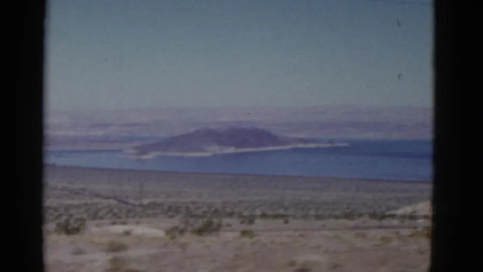 The closing frame returns to a California desert water view, with scrub in the foreground and a distant island or low hills across the water.