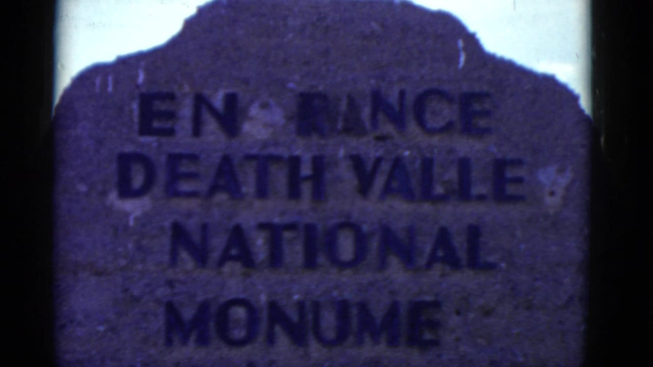Stone Death Valley National Monument entrance sign with bold dark lettering.