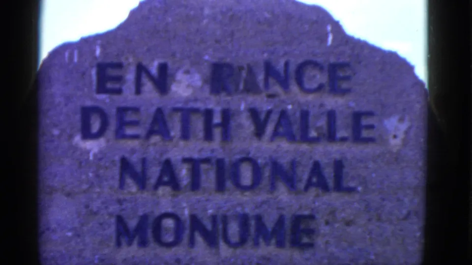 Weathered Death Valley National Monument marker appears in a blue-tinted 8mm frame from the supplied 1952 trip footage.