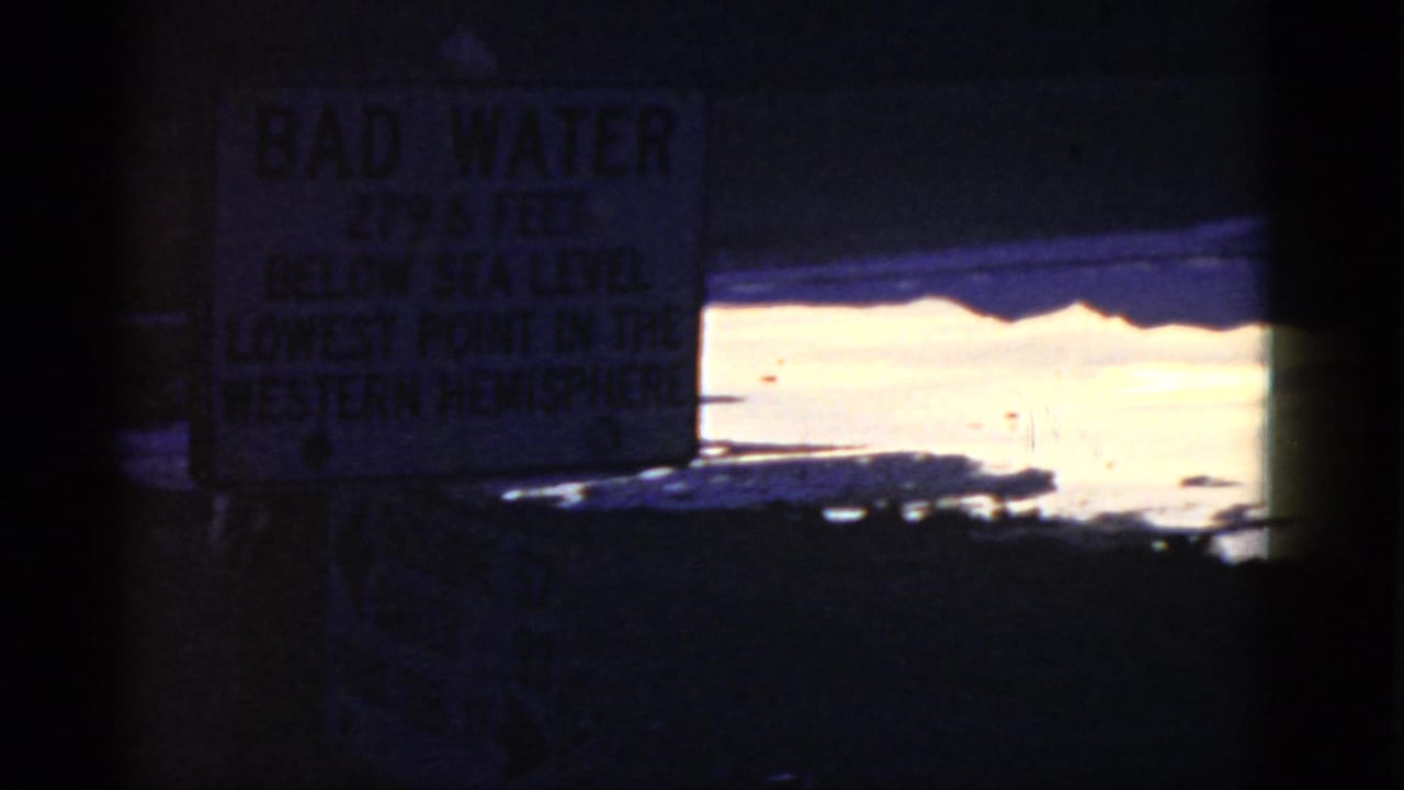 Bad Water sign centered above bright water and dark foreground shadows.