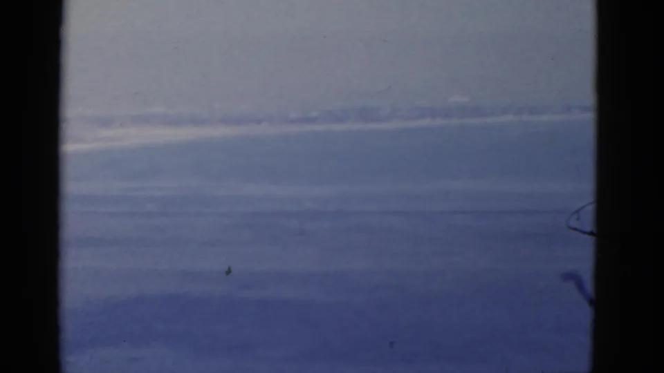 1952 California 8mm travel footage showing ocean, sky, and a faint shoreline through dark window framing.