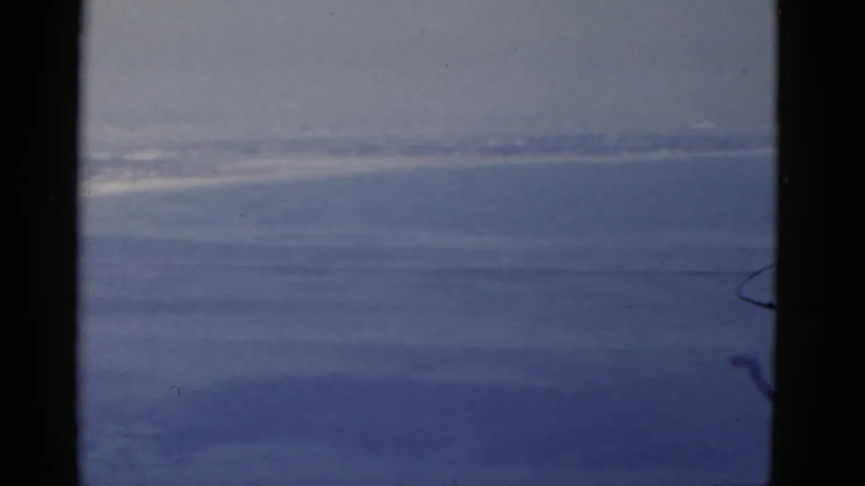 Soft 8mm view of California coastal water and a hazy distant shoreline from a moving travel perspective.