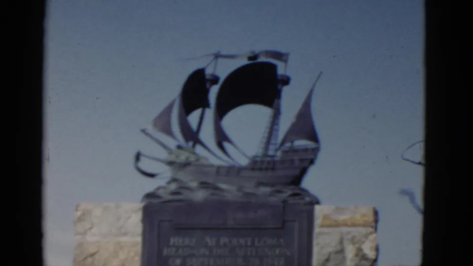 1952 Point Loma monument view showing a ship sculpture above a stone base, with plaque text visible but not fully legible.