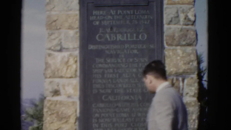 The visitor continues past the Cabrillo monument, with the plaque and stone wall filling most of the frame.
