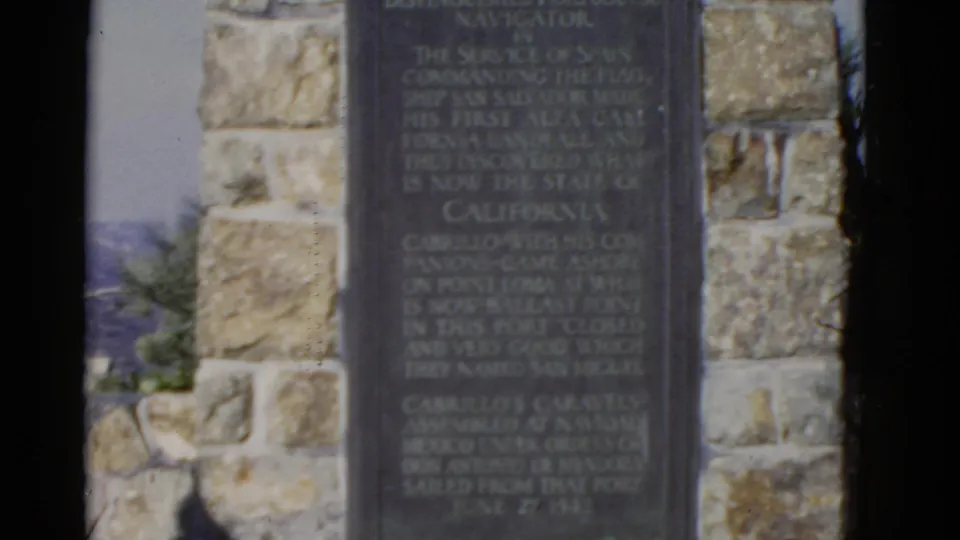 The Cabrillo National Monument plaque appears in a stone setting with landscape visible at the side.