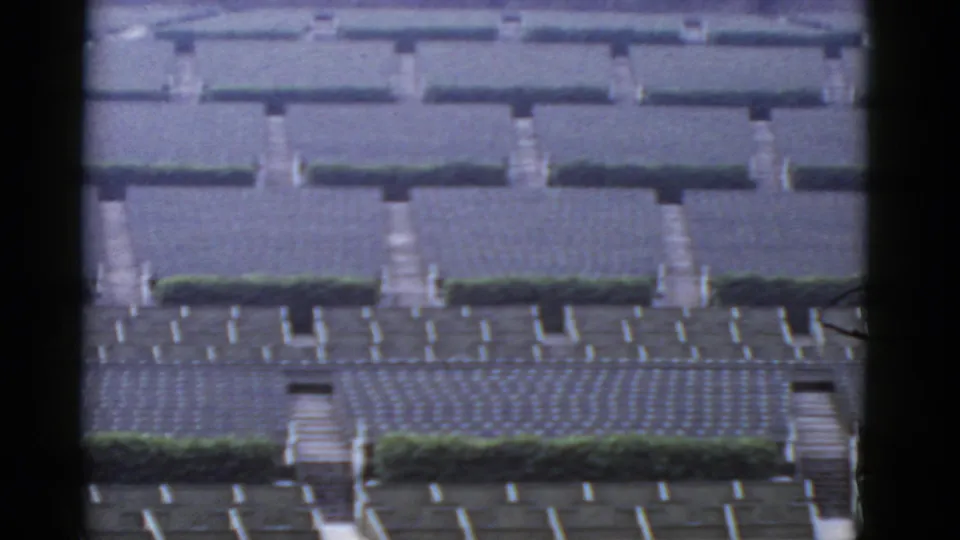 1952 California 8mm view of repeating gray bungalow housing rows with hedges and concrete walkways.