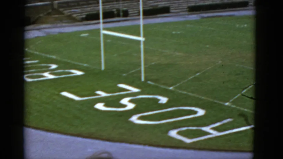 A 1952 California stadium view shows goal posts, green turf, white field markings, painted lettering, and empty bleachers.