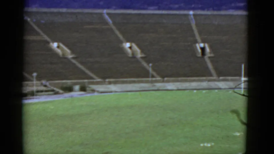 Final 1952 California stadium frame with vacant bleachers, green field surface, and visible 8mm film edge distortion.