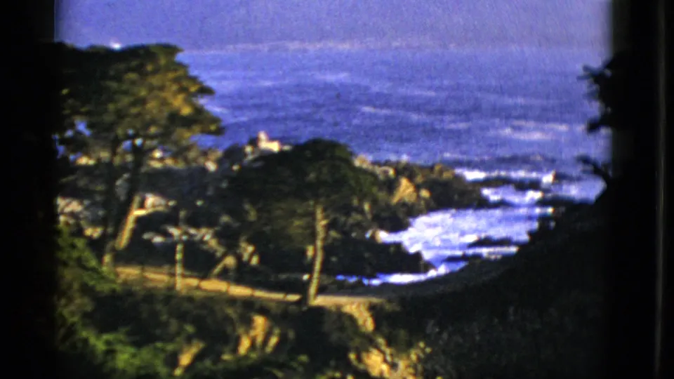 1952 San Francisco home-movie view of rocky coast, breaking Pacific surf, trees, and distant water from an elevated vantage point.