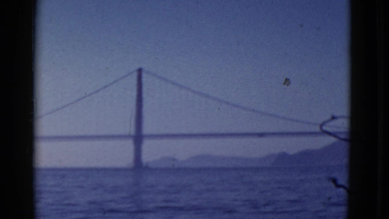 1952 San Francisco 8mm frame showing a likely Golden Gate Bridge view across water with hills in the distance.