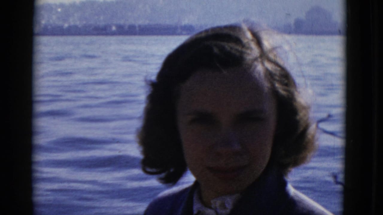 Young woman with dark styled hair faces the camera on San Francisco Bay in 1952 home-movie footage.