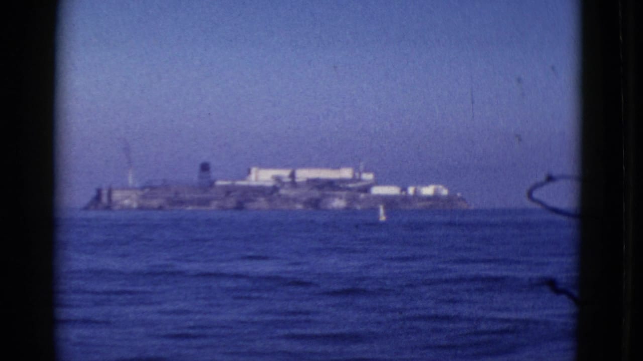 Distant 1952 San Francisco Bay view of Alcatraz Island, filmed from shore or a boat with open water in the foreground.