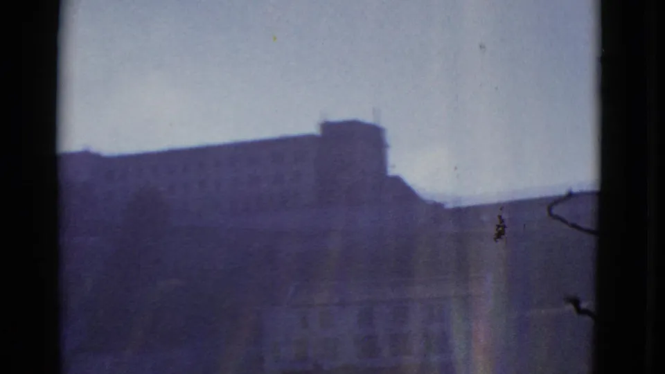 Distant San Francisco building roofline in 1952 8mm footage, with soft focus, dark borders, and no visible people or signage.